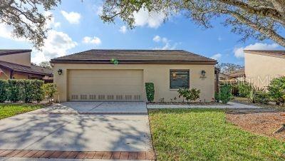 3692 Glen Oaks Manor Dr, Sarasota, FL 34232 - view of front of house with stucco siding, concrete driveway, a garage, and a front yard