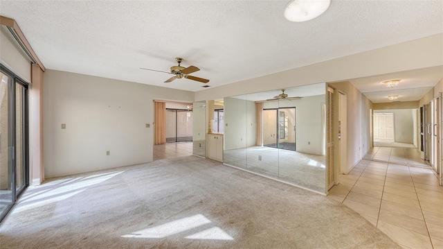 3692 Glen Oaks Manor Dr, Sarasota, FL 34232 - unfurnished bedroom with light tile patterned flooring, light carpet, a textured ceiling, and ceiling fan