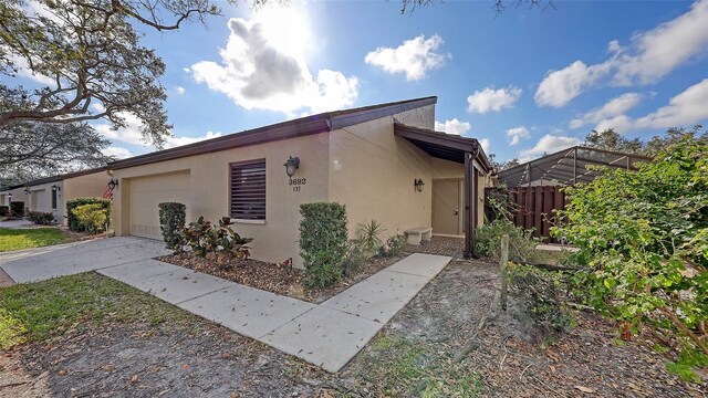 3692 Glen Oaks Manor Dr, Sarasota, FL 34232 - view of home's exterior with a garage, concrete driveway, and stucco siding