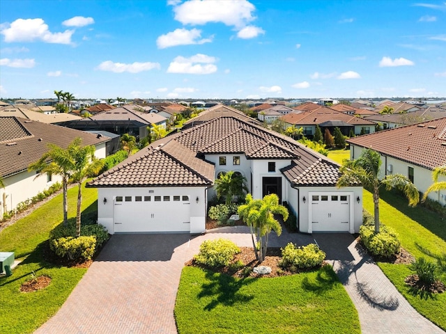 mediterranean / spanish-style home with a tiled roof, decorative driveway, a front yard, and a residential view