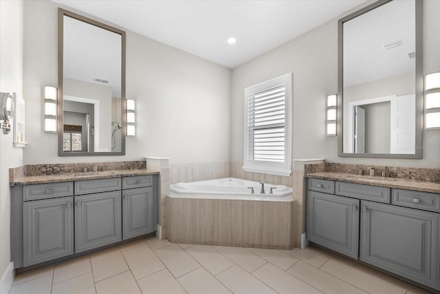 full bath with two vanities, a sink, and visible vents