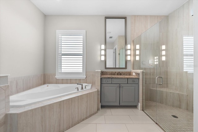 bathroom with a stall shower, vanity, a bath, and tile patterned floors