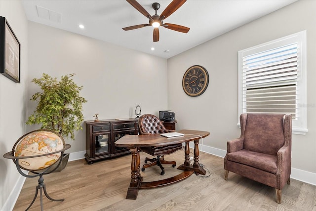 office area featuring light wood-style floors, visible vents, ceiling fan, and baseboards