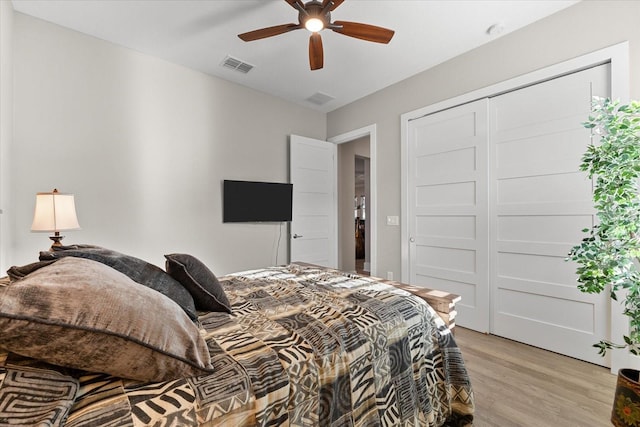 bedroom featuring light wood finished floors, a closet, visible vents, and a ceiling fan