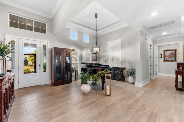 foyer featuring light wood-style flooring, visible vents, baseboards, and ornamental molding