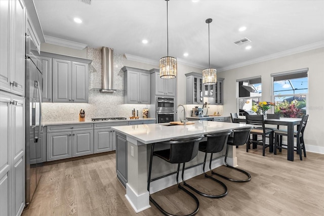 kitchen featuring stainless steel appliances, gray cabinets, visible vents, and wall chimney exhaust hood