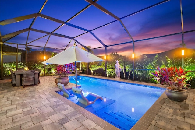 outdoor pool featuring a patio, outdoor dining area, and glass enclosure