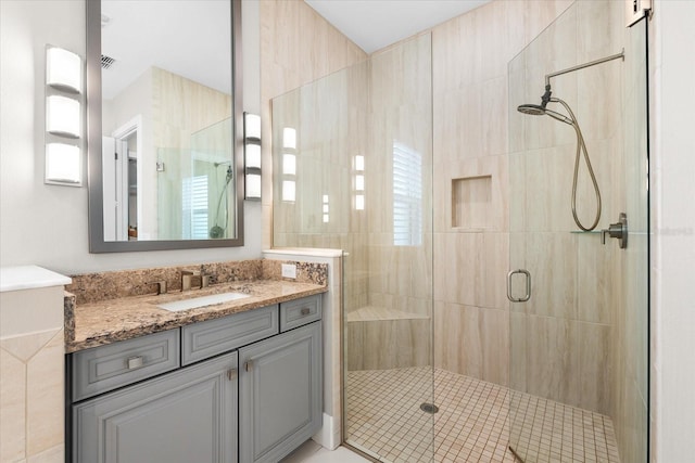 bathroom with a shower stall and vanity