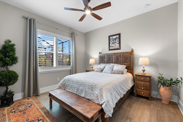 bedroom featuring light wood-style floors, baseboards, and a ceiling fan