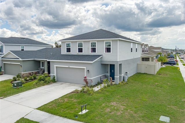 view of front facade featuring driveway, roof with shingles, fence, a front yard, and stucco siding