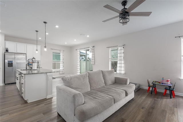 living area with recessed lighting, visible vents, ceiling fan, wood finished floors, and baseboards