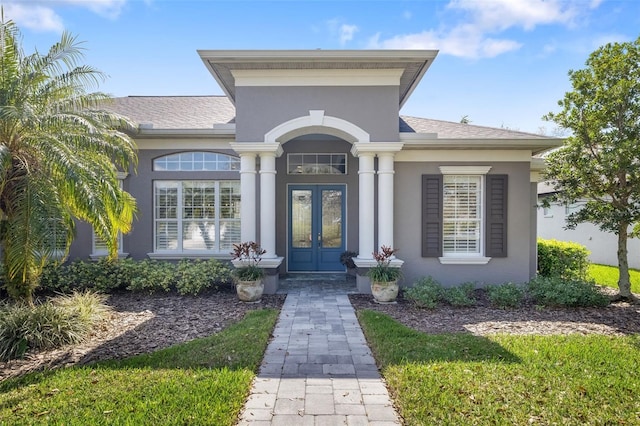 doorway to property with stucco siding, a shingled roof, and french doors