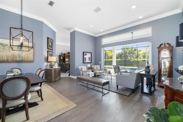 living room with crown molding, visible vents, and wood finished floors