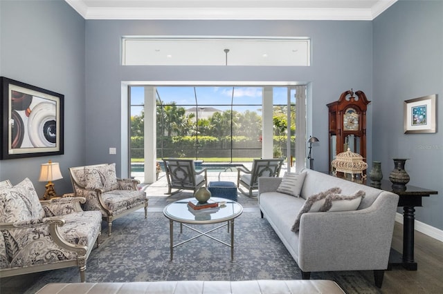 living area with crown molding, baseboards, and wood finished floors