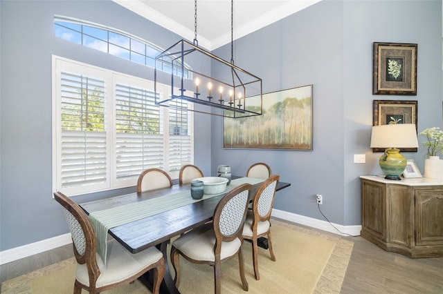 dining room featuring baseboards, light wood-style flooring, and crown molding