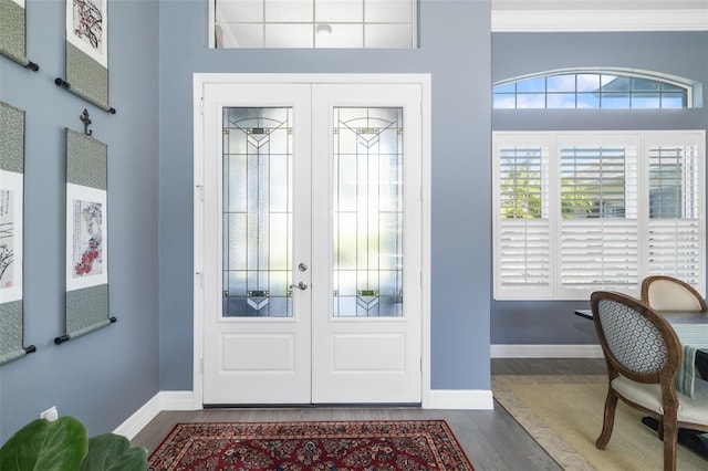 foyer featuring dark wood-type flooring, french doors, and baseboards