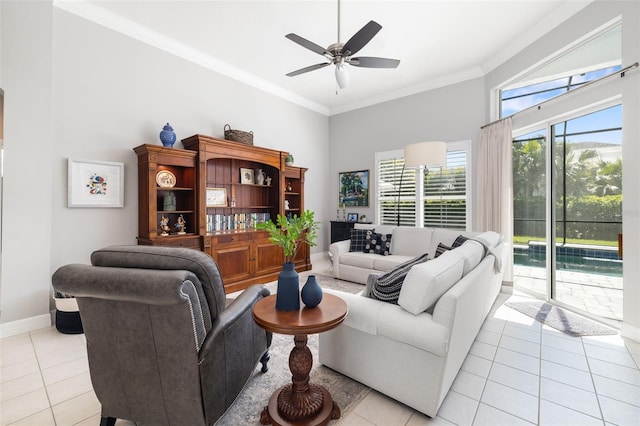 living area with ceiling fan, baseboards, crown molding, and light tile patterned flooring