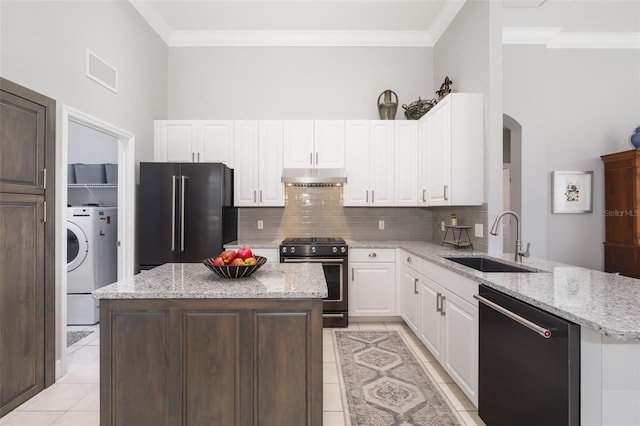 kitchen with dishwashing machine, high end black refrigerator, under cabinet range hood, a sink, and range