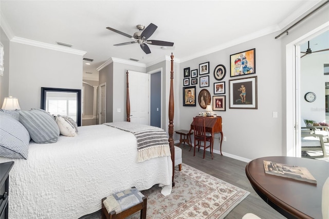 bedroom featuring baseboards, wood finished floors, visible vents, and crown molding