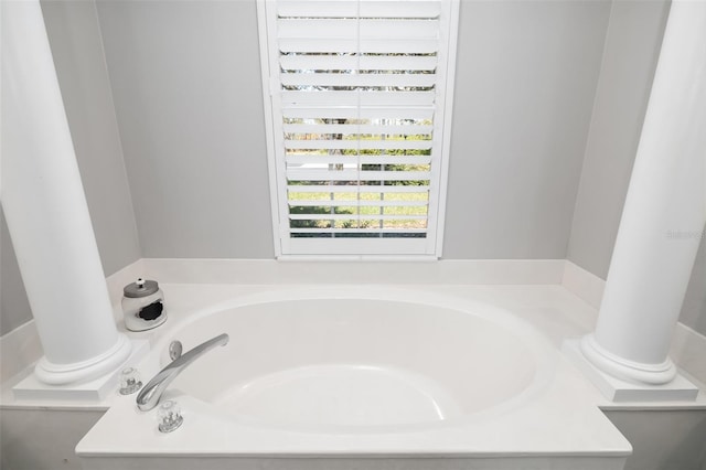 bathroom with a garden tub and decorative columns