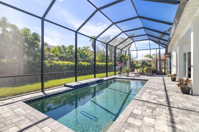 outdoor pool featuring glass enclosure and a patio