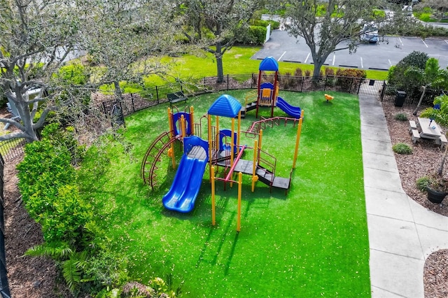 community play area with a yard and fence