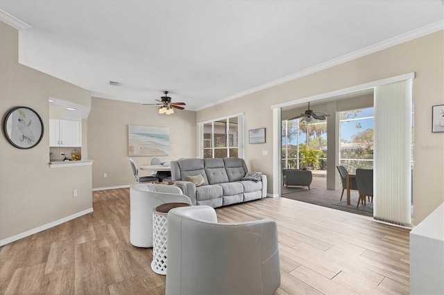 living room with baseboards, ornamental molding, and light wood-style floors