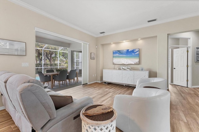 living room with ornamental molding, visible vents, baseboards, and wood finished floors