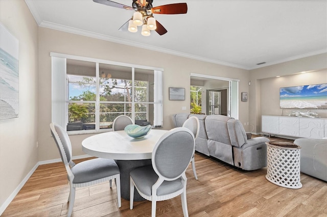 dining space featuring light wood finished floors, ceiling fan, baseboards, and ornamental molding