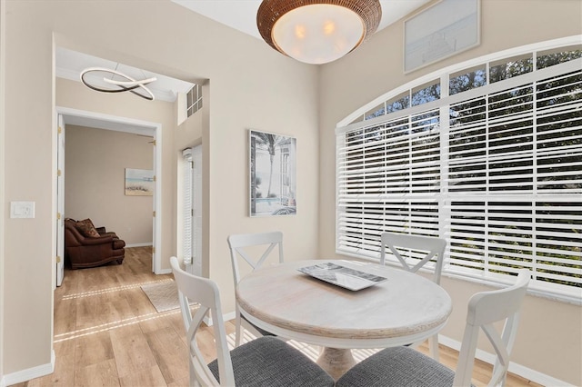 dining space with visible vents, baseboards, a chandelier, and wood finished floors