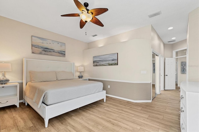 bedroom with a ceiling fan, baseboards, visible vents, and light wood finished floors