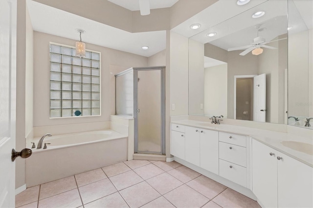 full bath with double vanity, ceiling fan, tile patterned floors, a garden tub, and a shower stall