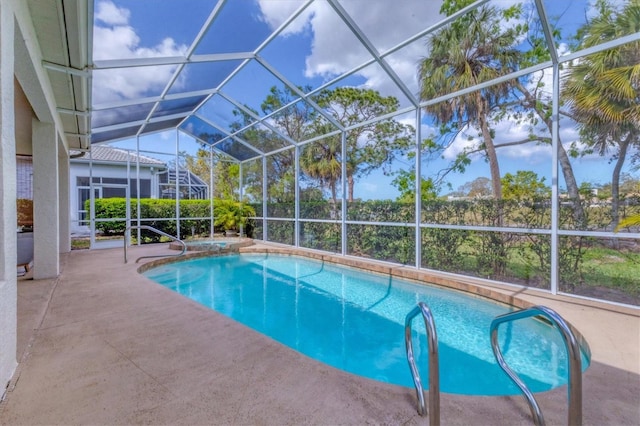 outdoor pool with glass enclosure and a patio area