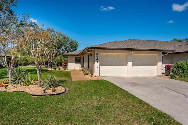 single story home with a garage, a shingled roof, concrete driveway, stucco siding, and a front lawn