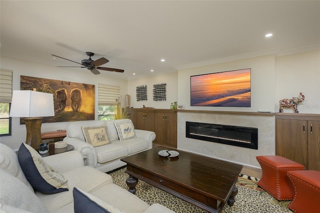 living area with recessed lighting, ornamental molding, and a glass covered fireplace