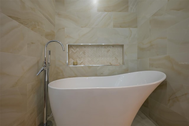 full bath featuring a soaking tub and tile walls