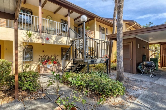 view of property with stairway and an attached carport