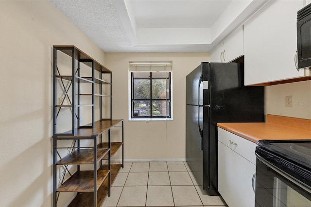 kitchen featuring light tile patterned floors, baseboards, light countertops, black appliances, and white cabinetry