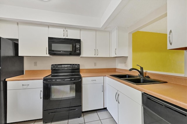 kitchen with light countertops, black appliances, white cabinetry, a sink, and light tile patterned flooring