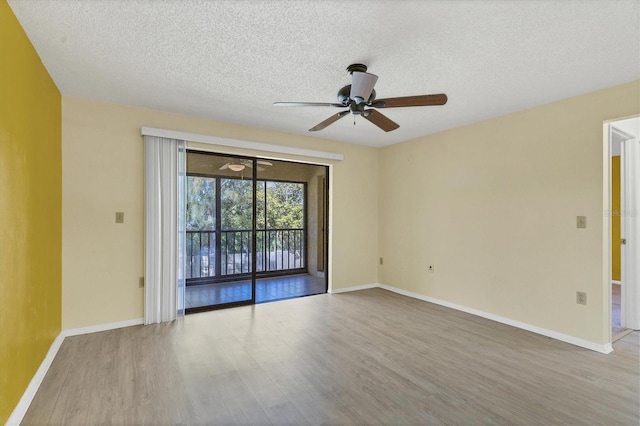 spare room featuring ceiling fan, a textured ceiling, baseboards, and wood finished floors