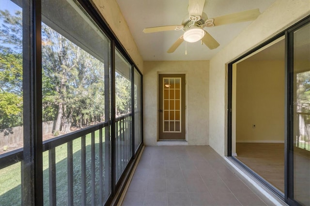 unfurnished sunroom featuring a ceiling fan