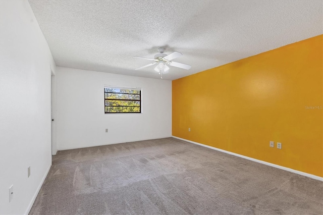 empty room with carpet flooring, ceiling fan, a textured ceiling, and baseboards