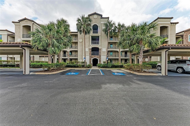 view of property featuring covered and uncovered parking