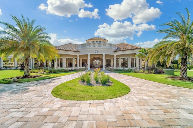 view of community with a yard and curved driveway