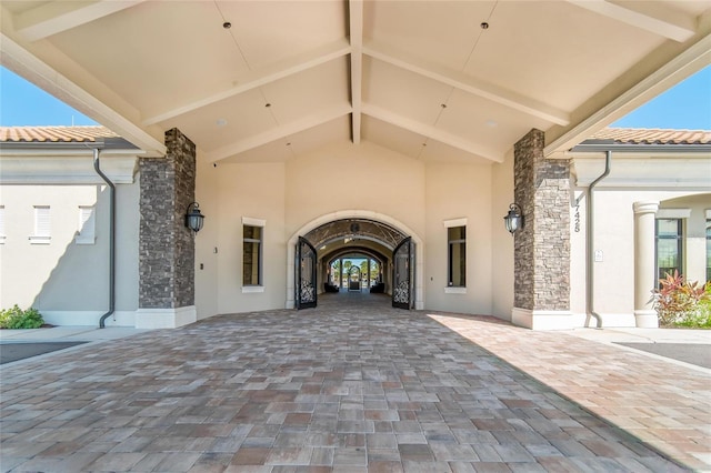 entrance to property with stone siding, a tiled roof, and stucco siding