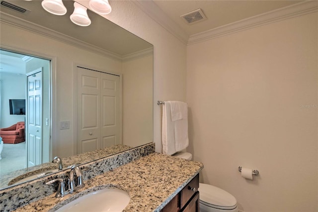 half bathroom featuring toilet, vanity, visible vents, and crown molding