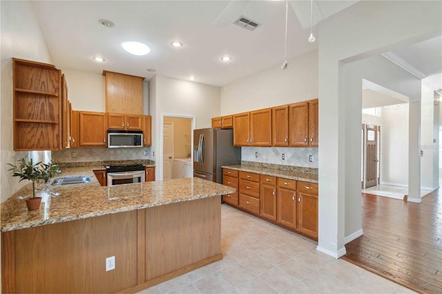 kitchen featuring tasteful backsplash, visible vents, appliances with stainless steel finishes, light stone countertops, and open shelves