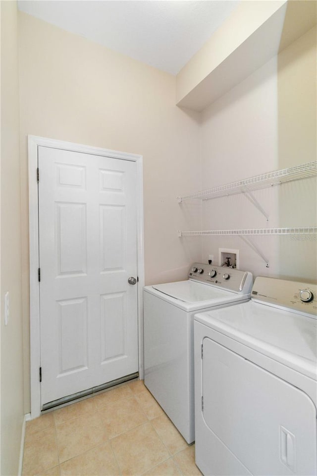 laundry area with light tile patterned floors, laundry area, and washer and clothes dryer