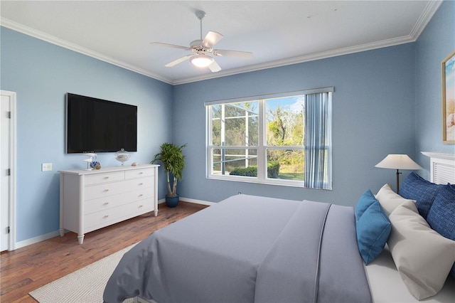 bedroom featuring crown molding, baseboards, and wood finished floors