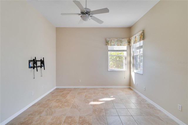 empty room featuring ceiling fan, light tile patterned floors, and baseboards